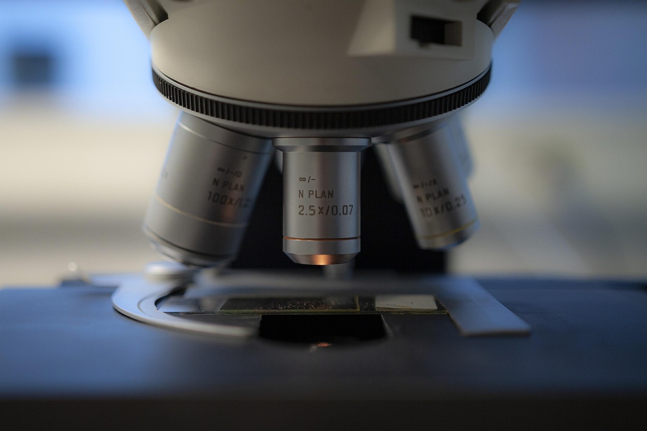 Primer plano de los objetivos de un microscopio sobre una muestra en la platina